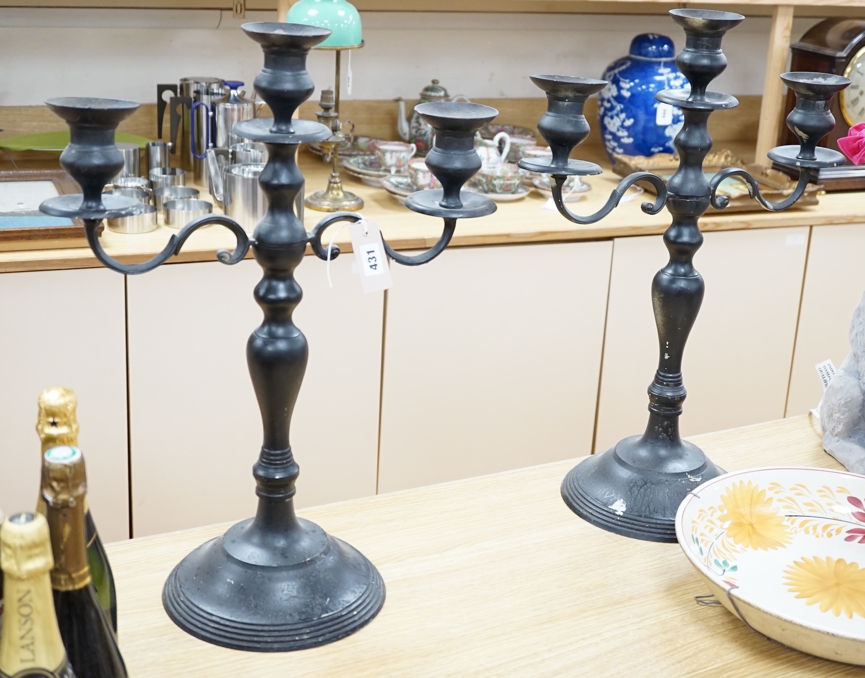 A pair of metal three branch candelabra, 60cm high